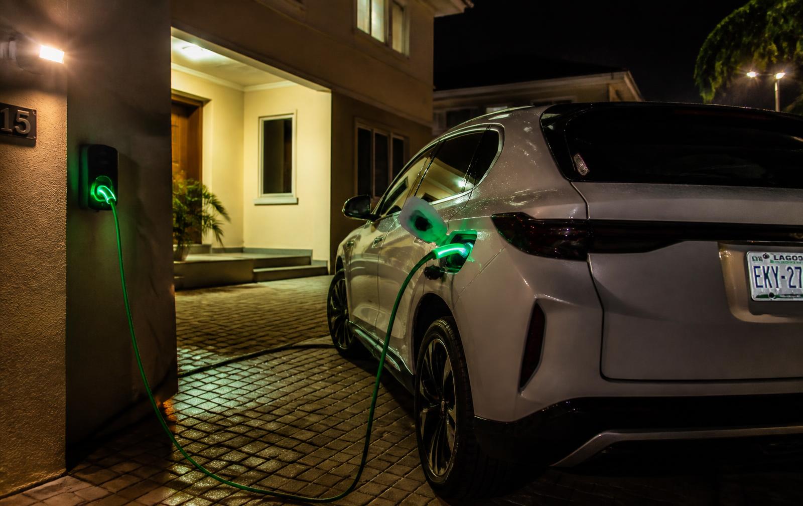 Electric car charging overnight on a wall charger in the driveway of a Nigerian home